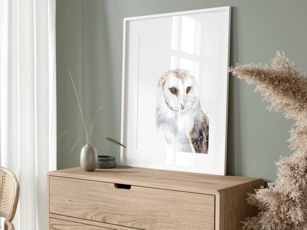 Barn owl print framed on a dressing table against a green wall