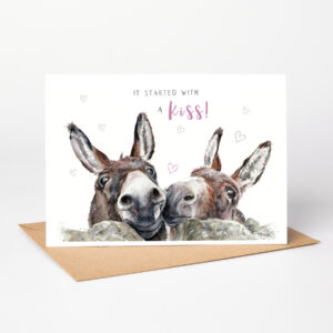 Donkey duo love card. Watercolour illustration of two affectionate donkeys with the text “It started with a kiss!” on a greetings card.